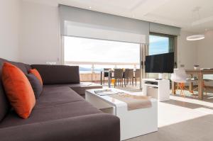 sala de estar con sofá y TV en Apartment Las Canteras Nautilus 8D, en Las Palmas de Gran Canaria