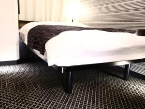 a bedroom with two beds with white sheets at APA Hotel Shibuya Dogenzakaue in Tokyo