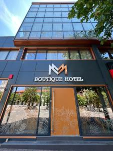 a sign for a boutique hotel in front of a building at MM Boutique Hotel in Burgas