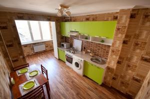 a kitchen with green cabinets and a table and a sink at Cozy flat apartment in Chişinău