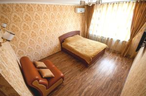 a bedroom with a bed and a chair and a window at Cozy flat on Pushkin 33 in Chişinău