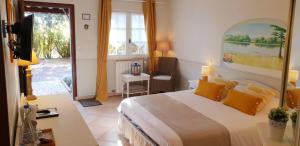 una camera da letto con un letto, una tv e una finestra di le Mas des Cigales a Tourrettes-sur-Loup