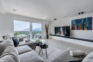 a living room with a couch and a large window at VILLA Bella CANNES Croix des Gardes in Cannes
