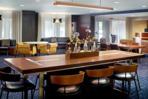 マートルビーチにあるCourtyard by Marriott Myrtle Beach Broadwayの大きな木製テーブルと椅子が備わるレストラン