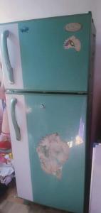 a green and white refrigerator in a room at Dinu Senu Dream Guest in Midigama East