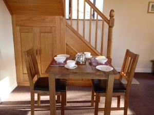 a wooden table with two chairs and a wooden staircase at Orchard House Bed and Breakfast in Grassington