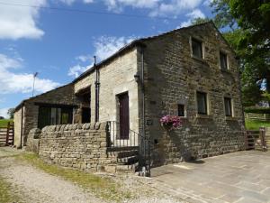 un antiguo edificio de piedra con una puerta roja en Orchard House Bed and Breakfast en Grassington