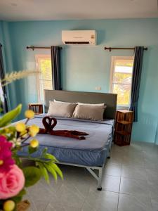 a bedroom with a bed with a ribbon on it at Twocans Garden Village KohMak in Ko Mak
