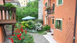 a garden with flowers and an umbrella on a balcony at La Nicchia in Tarzo