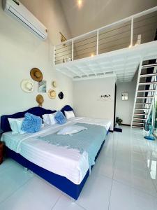 a bedroom with a large bed with blue pillows at บ้านบลูสกาย POOL VILLA Cha-am in Cha Am +16 photos