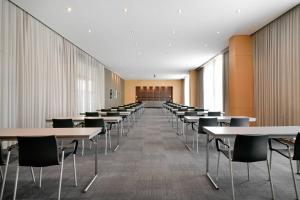 a row of tables and chairs in a room at AC Hotel Firenze by Marriott in Florence