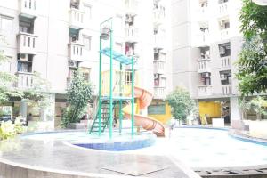 a playground in front of a building with a slide at OYO 93545 Gateway Cicadas Apartment By Barbie Homestay in Bandung