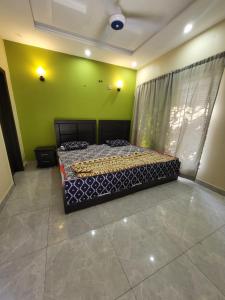 a bedroom with a bed and a green wall at Beautiful villa in bahria town karachi in Karachi