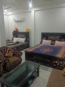 a room with a bed and a couch and a table at Pooja homestay in Prayagraj