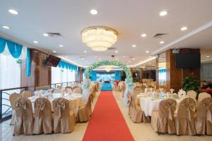 a banquet hall with tables and chairs and a red carpet at Xinyuan Hot Spring Hotel in Haikou +279 photos