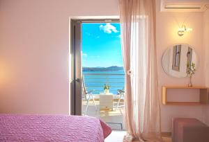 una camera da letto con porta che si apre su una vista sull'oceano di Villa Maria PF a Nydri