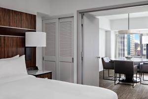 a bedroom with a bed and a dining room with a table at New York Marriott Marquis in New York