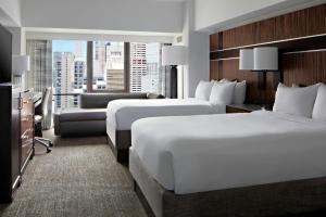 two beds in a hotel room with a view of a city at New York Marriott Marquis in New York