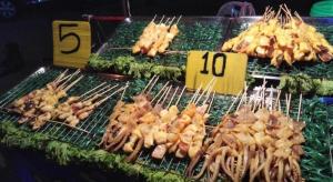 un mucchio di cibo su una griglia con delle pinze di Ban Bua Resort and Hotel a Khon Kaen