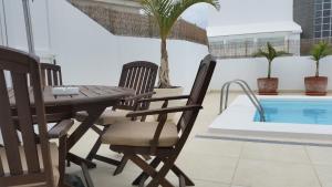 a patio with a table and chairs next to a pool at Villa Cristina in Puerto del Carmen