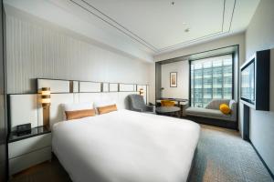 a hotel room with a large white bed and a window at KOKO HOTEL Premier Nihonbashi Hamacho in Tokyo +96 photos
