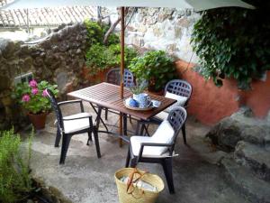 a table and chairs with an umbrella on a patio at La Casita del Tejo in Hervás +57 photos