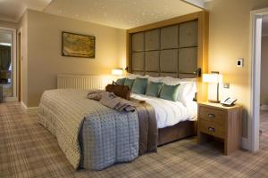 a hotel room with a bed and two lamps at Carden Park Hotel, Golf Resort and Spa in Tilston