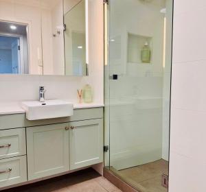 a bathroom with a sink and a shower at Perfect Oceanfront Cottesloe apartment in Perth