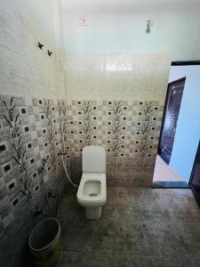 a bathroom with a white toilet in a room at Comfort Home in Bhopal