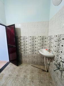 a bathroom with a sink and a red door at Comfort Home in Bhopal