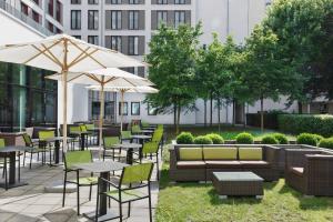 an outdoor patio with tables and chairs and umbrellas at Courtyard by Marriott Munich City East in Munich