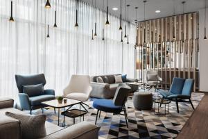 a lobby with chairs and a couch and tables at Courtyard by Marriott Munich City East in Munich