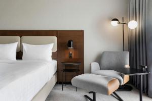 a hotel room with a bed and a chair at Courtyard by Marriott Munich City East in Munich