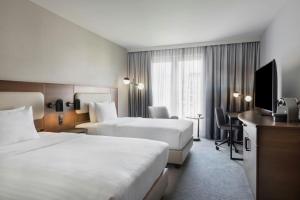 a hotel room with two beds and a television at Courtyard by Marriott Munich City East in Munich