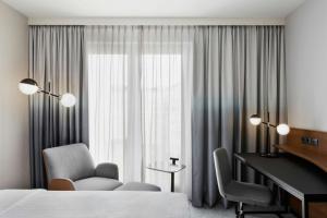 a hotel room with a bed and a desk and a piano at Courtyard by Marriott Munich City East in Munich