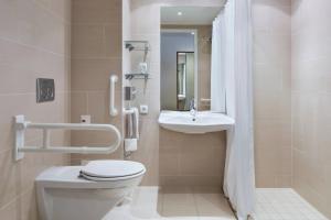 a bathroom with a toilet and a sink at Courtyard by Marriott Munich City East in Munich