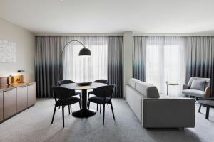 a living room with a table and chairs and a couch at Courtyard by Marriott Munich City East in Munich
