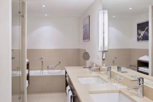 a bathroom with two sinks and a tub at Courtyard by Marriott Munich City East in Munich