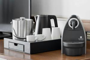 a black coffee maker and cups on a table at Courtyard by Marriott Munich City East in Munich