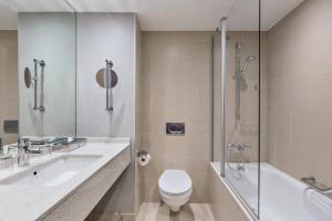 a bathroom with a toilet and a sink and a shower at Courtyard by Marriott Munich City East in Munich