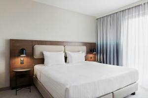 a bedroom with a large white bed and a window at Courtyard by Marriott Munich City East in Munich