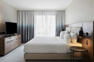 a hotel room with a large bed and a television at Courtyard by Marriott Munich City East in Munich
