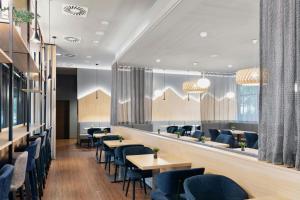 a restaurant with blue chairs and tables at Courtyard by Marriott Munich City East in Munich