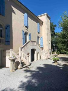 ein großes Haus mit einer Treppe davor in der Unterkunft Ferrabouc in Mas-Saintes-Puelles