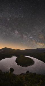 un gran lago de noche con un cielo estrellado en Casa Rural Arroal, en Sotoserrano