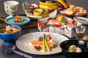 a table with plates of food and bowls of food at Inatori Ginsuiso in Higashiizu +61 photos