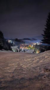 a field at night with a city in the background at Friends Vlašić in Vlasic +6 photos