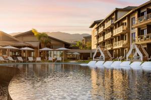 ワイレアにあるAC Hotel by Marriott Maui Waileaのホテルのスイミングプール(椅子、パラソル付)