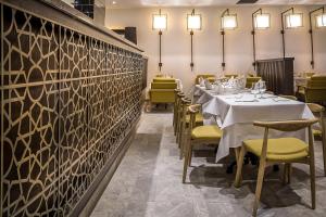 a dining room with tables and yellow chairs at Azalaï Hôtel Nouakchott in Nouakchott