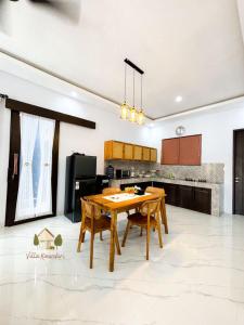 a kitchen with a wooden table and chairs at Villa Kinandari 2 Candidasa in Candidasa +8 photos